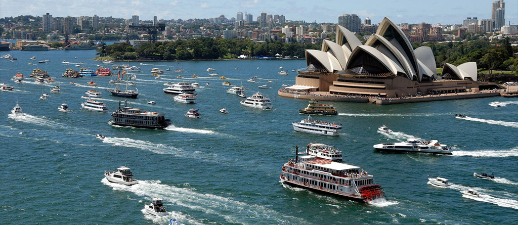 Australia Day Harbourfest on Sydney Harbour with ferries & boats surrounding the Sydney Opera House and city skyline during daytime.
