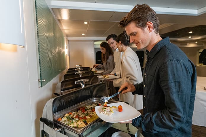 Guests help themselves to unlimited multi-cuisine buffet on the Magistic cruise