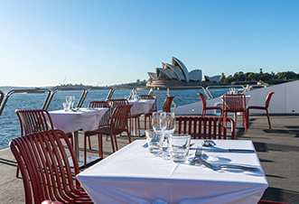 Dining experience at the backdrop of the Opera House aboard a modern catamaran.
